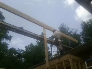 Carpenter setting a ridge beam over a new addition frame — Ice Dam Removal by Roofing Brothers in New Orleans