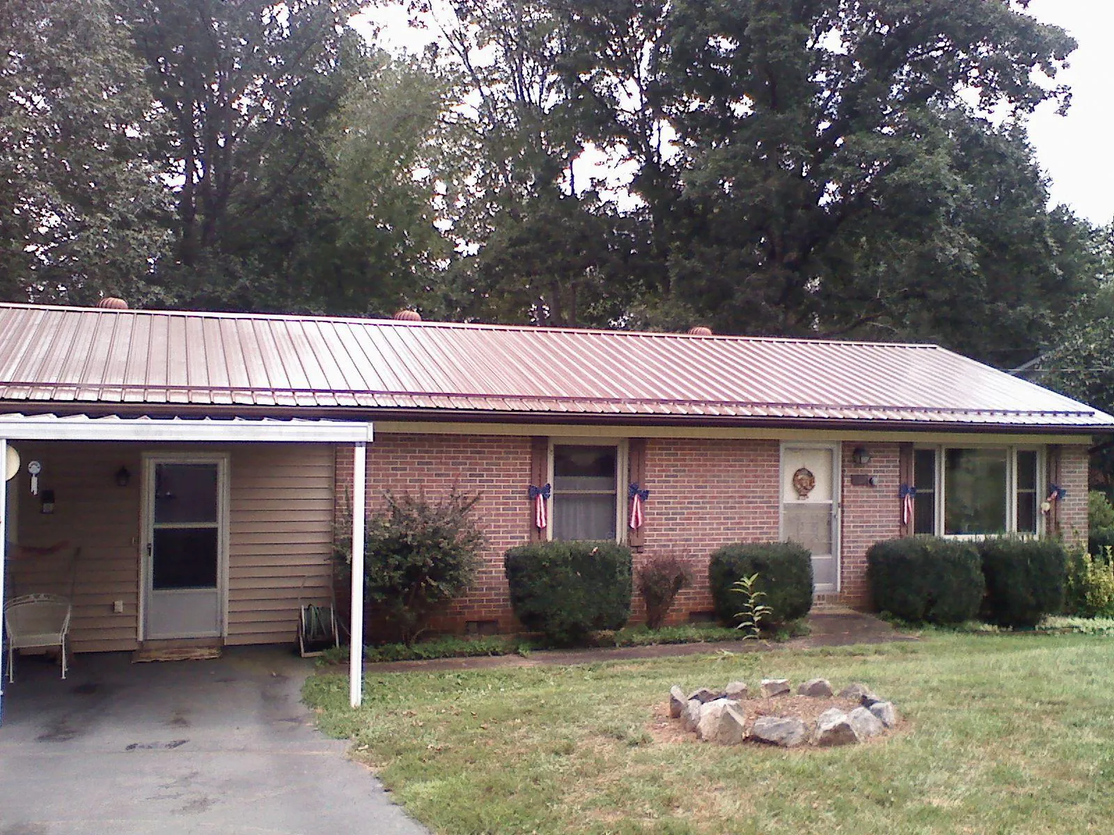 Bronze metal roof and carport on a brick ranch home — Roof Repair work by our crew in New Orleans
