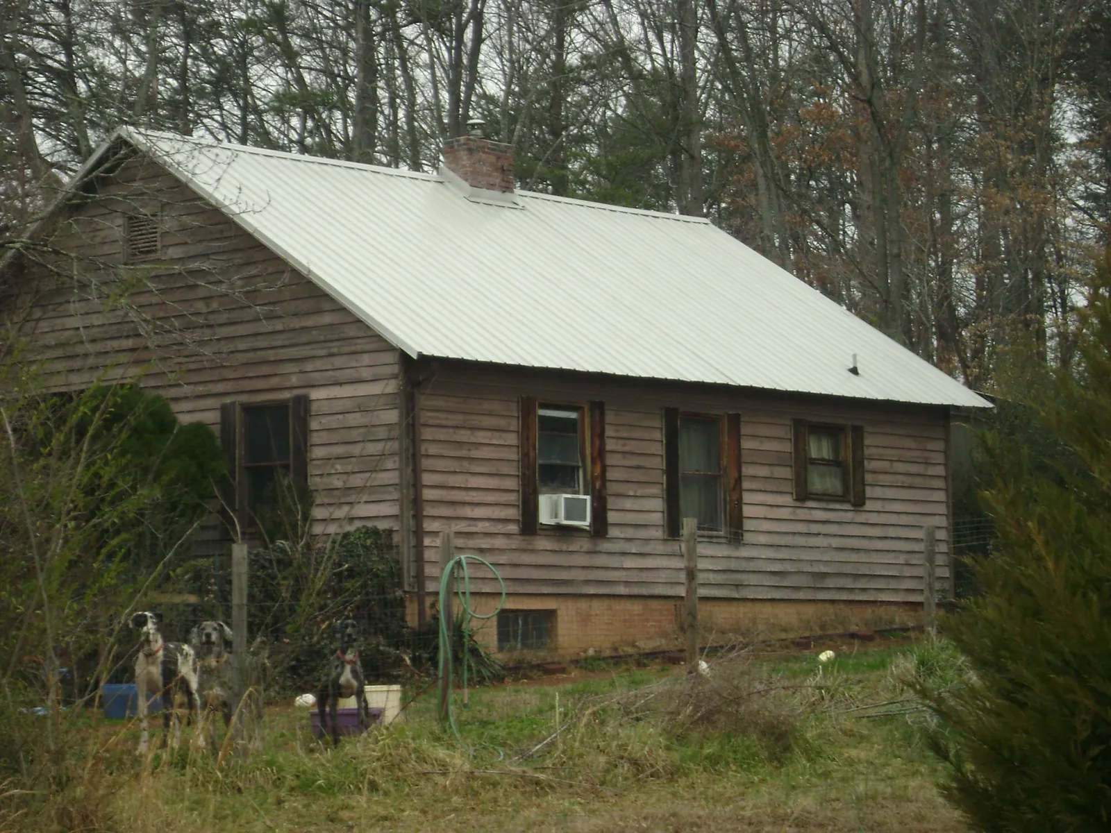 White metal roof on an old wood sided farmhouse, from a Asphalt Shingle Roof Repair job in New Orleans